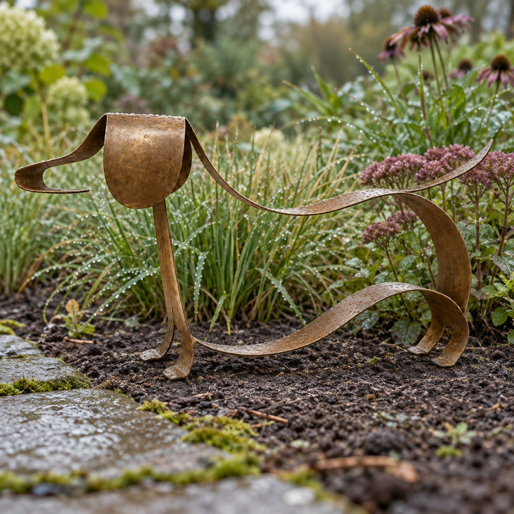 LoyalPaw metal dachshund sculpture in a garden flower bed
